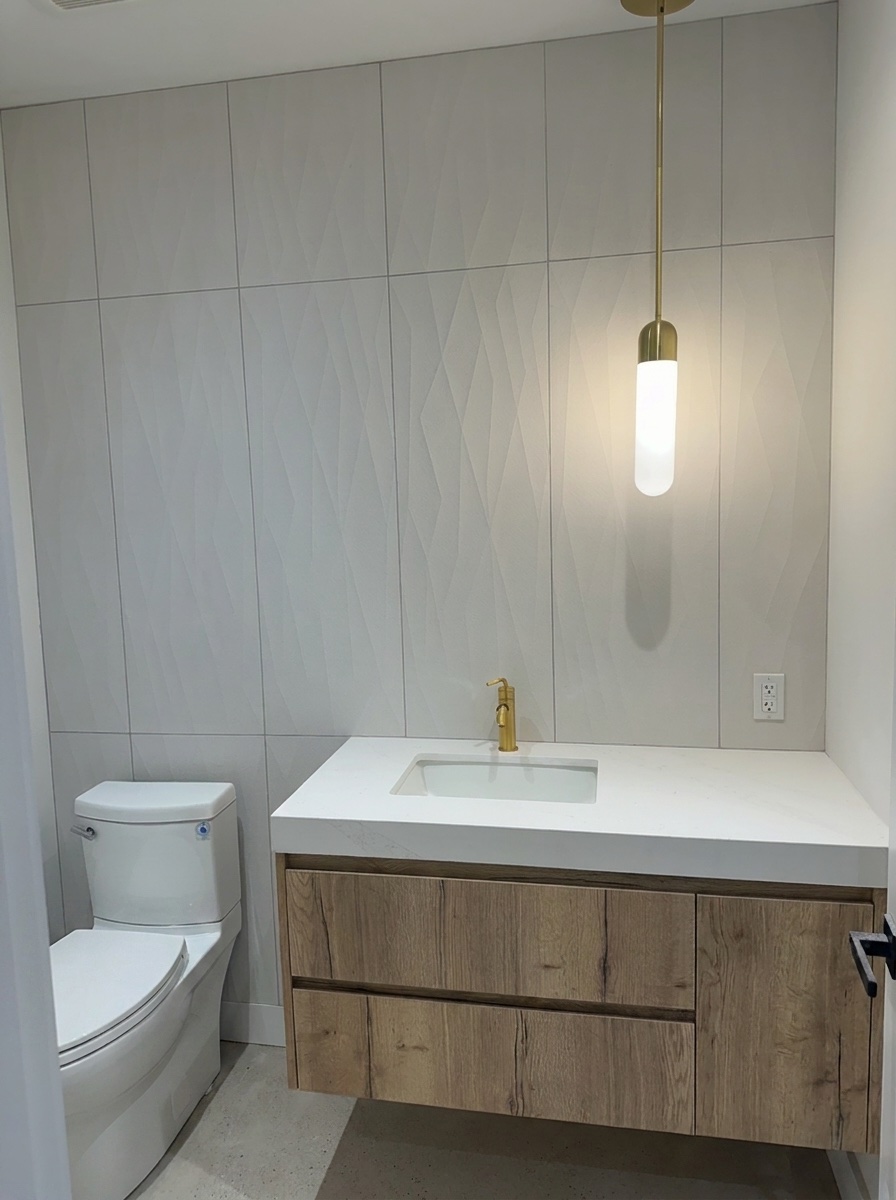 Powder room with floating oak vanity, sculpted feature-tile wall, and brass pendant