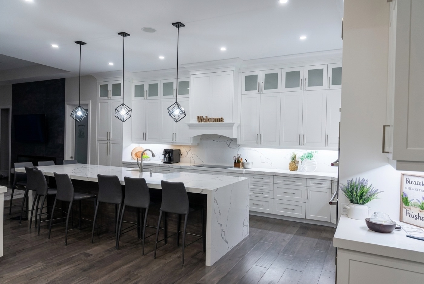 Custom white kitchen with waterfall quartz island and pendant lighting